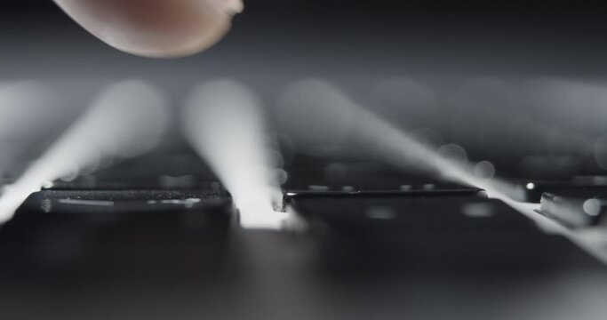 Extreme Close-up of Fingertip Pressing Single Key on Laptop Keyboard