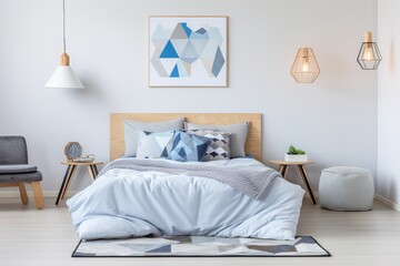 a modern bedroom with a wooden bed, white walls, and a geometric blue and white rug. The room has a minimalist design with a wooden nightstand, a gray armchair, and a white pouf. 