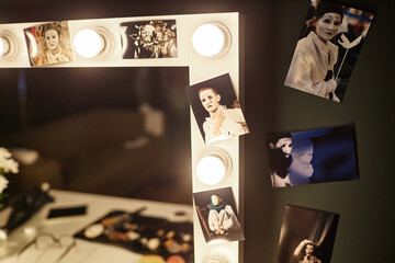 Close up of vanity table with assorted pictures of performer framing mirror, copy space