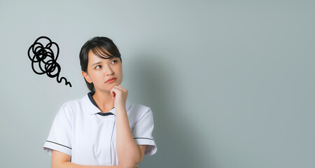 悩む白衣を着た女性