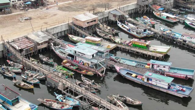 Aerial footage of boats docked at the pier in a slum and densely populated area in Cilingcing, Tanjung Priok, North Jakarta | Perahu kayu bersandar di Dermaga Wilayah kumuh padat penduduk 4K Drone