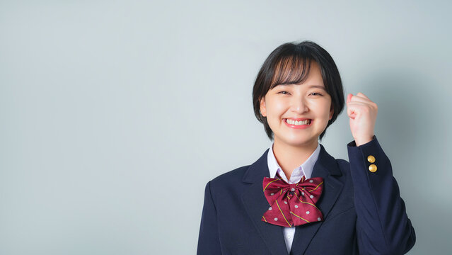 ガッツポーズする制服を着た女子学生