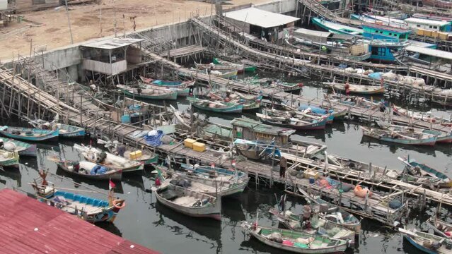 Aerial footage of boats docked at the pier in a slum and densely populated area in Cilingcing, Tanjung Priok, North Jakarta | Perahu kayu bersandar di Dermaga Wilayah kumuh padat penduduk 4K Drone