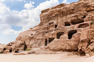 Rocks dotted with the caves carved by Nabatean craftsmen in Nabatean Kingdom of Petra in the Wadi Musa city in Jordan