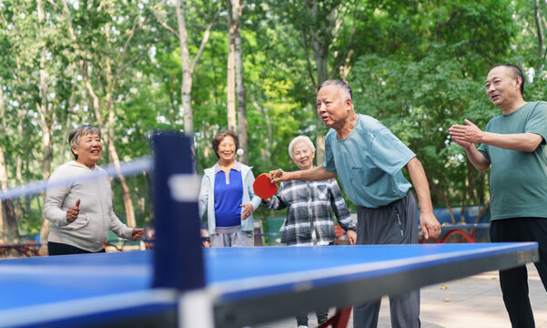 Old people playing table tennis in the park