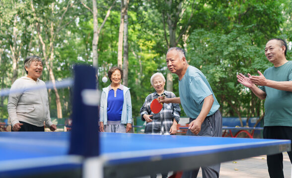Old people playing table tennis in the park