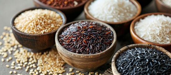 Different varieties of grains like Nerone rice, organic forbidden black, brown rice, and white Jasmine Rice displayed on a table top.