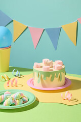 Paper-crafted birthday cake with marshmallow decor, balloons, and ribbons grace the table. A festive flag string hangs against a blue backdrop, scene for a birthday celebration.