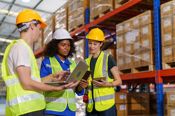 A diverse team of warehouse personnel is conducting a comprehensive stock inventory using laptop...