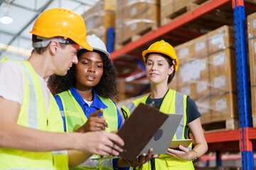 A diverse team of warehouse personnel is conducting a comprehensive stock inventory using laptop...