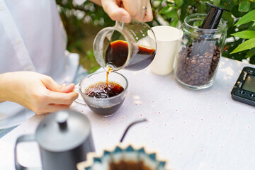 Happy Asian beautiful woman making a specialty coffee in morning at her backyard garden, woman...