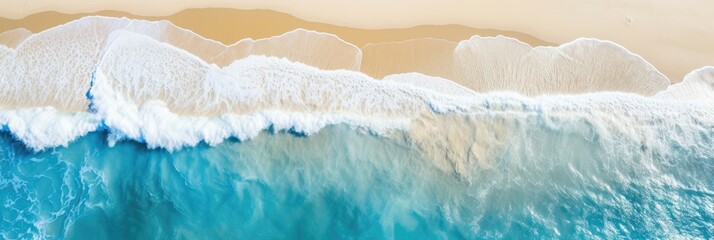 Aerial view of gentle waves washing onto a sandy shore, creating a serene beachscape.