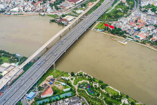 Aerial view over a busy city bridge crossing a wide murky river at Ho Chi Minh City in Vietnam