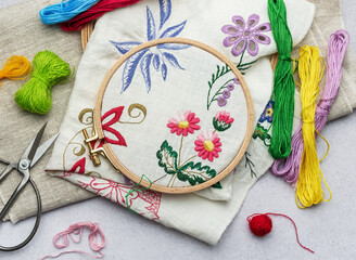 The process of hand embroidering a napkin with colored threads on white fabric.
