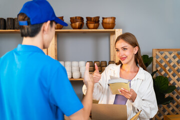 The courier wears a uniform and carries the package or goods to deliver to the customer. Woman...