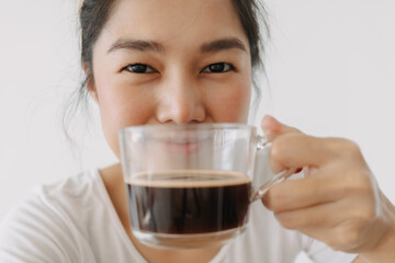 Close up of woman holding and showing hot coffee mug in front, happy smiling drink tea cup in the morning, isolated over white background wall.