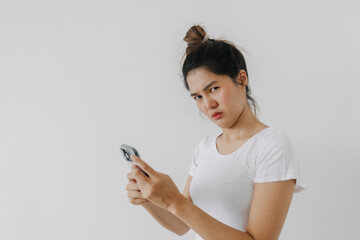 Asian Thai woman using mobile phone with funny doubt face, holding smartphone by silent suspicious, standing isolated over white background wall.