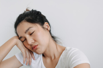 Asian Thai woman closing eyes and resting head on hand, take selfie with bored face, unhappy isolated over white background wall.
