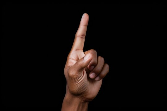 A person holding up a finger on a black background. Generative AI.