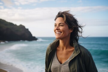 Portrait of smiling woman standing on the beach with ocean in background