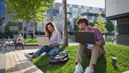 Adult students study outside with laptop together. Casual man talking friend - Powered by Adobe