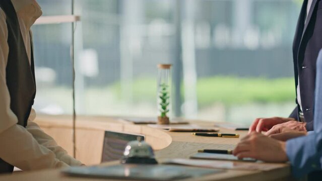 Receptionist hands giving keys at hotel counter closeup. Tourist couple check in
