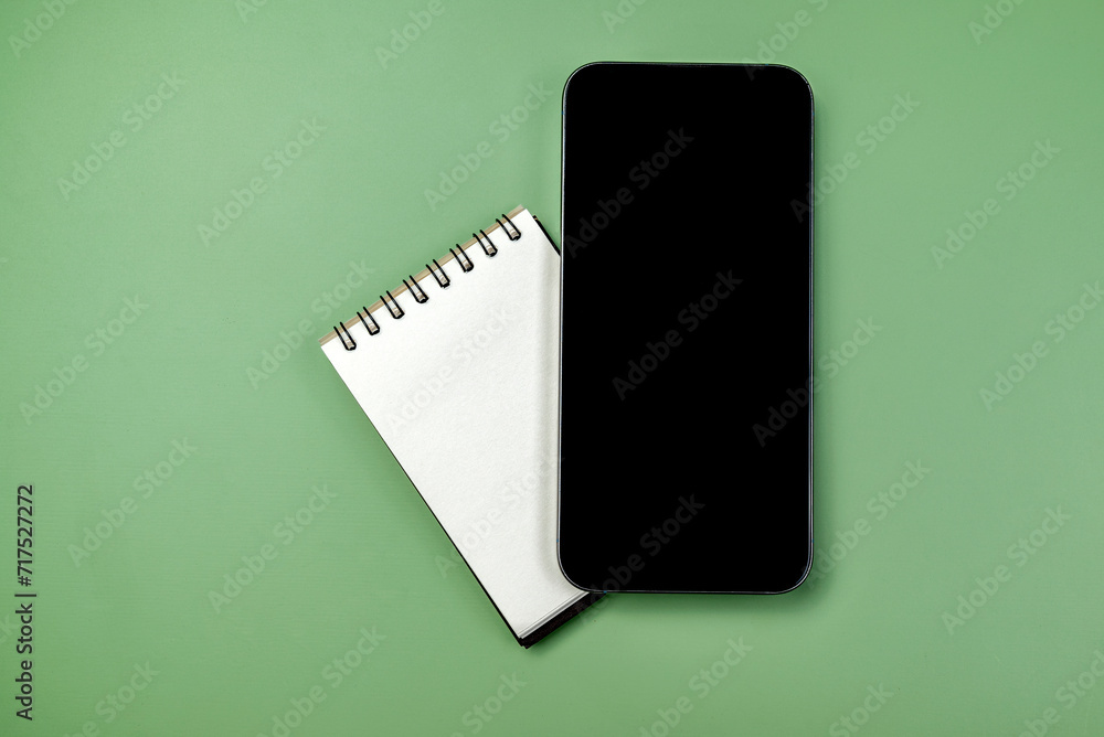 Aufkleber closeup view of mobile phone with blank screen and an empty notebook