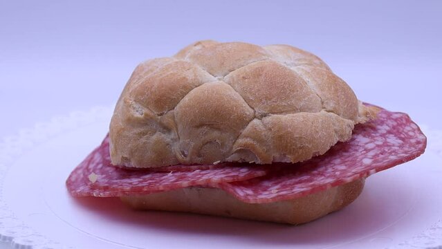Italian panino al salame, salami sandwich rotating on a turntable. 