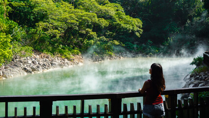 Hot spring water at Beitou Thermal Valley or Geothermal Valley, Taiwan. Woman traveler looking at...