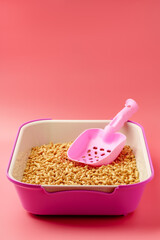 Pet litter box with bio filler on pink background