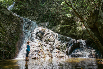 Asian woman backpacker looking at the waterfall in jungles. Ecotourism concept image travel Asian...