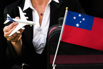 business woman holds toy plane travel bag and flag of Samoa
