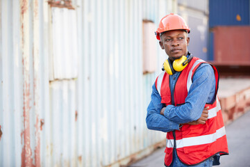 portrait African factory worker or engineer folded arms pose in containers warehouse storage