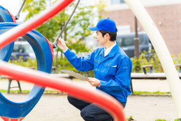 公園の遊具を安全点検する男性作業員