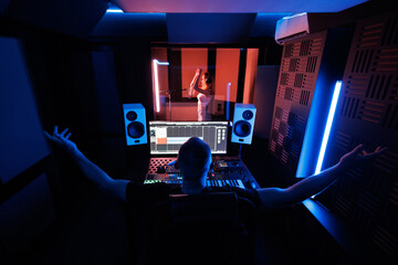 The sound engineer makes a recording in the studio and adjusts the sound parameters. A young female...