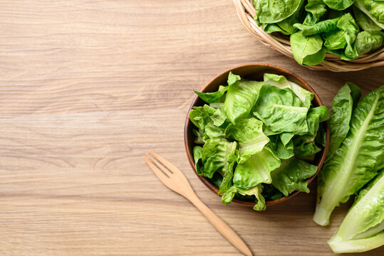 Organic cos romaine lettuce in wooden bowl, Food ingredient for healthy salad