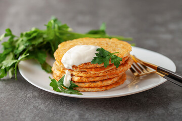 Potatoes pancakes latkes, flapjacks, hash brown or potato vada with parsley and sour cream  on table.