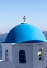 Fototapeta na wymiar View from viewpoint of Oia village with blue dome of greek orthodox Christian church. Santorini, Greece