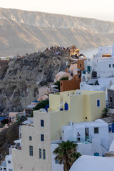 Whitewashed buildings and the ruins of Castle of Agios Nikolaos on the edge of the caldera cliff,...