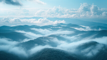 Obraz premium A mountaintop view where clouds and fog merge, blurring the horizon.