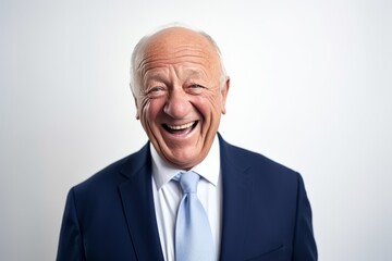 Elderly businessman laughing and looking at the camera on a gray background