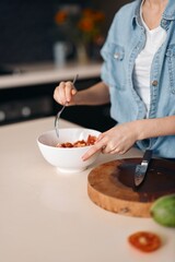 Fresh and Healthy: Beautiful Woman Cooking a Vegetarian Salad in a Kitchen