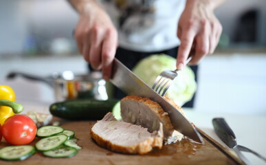 Hands chop ready baked pork meat and vegetables. An online course on modern cooking. Choose and combine different products. Eat more fully and variably. Finish cooking meat dishes