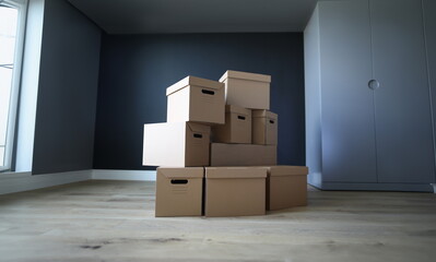 Empty cardboard boxes stand in an empty room. Empty office interior, boxes stand on floor. Loading property in boxes. Items are reliably protected from damage during loading and transportation