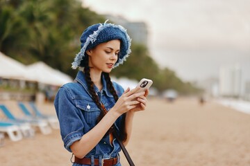 Beauty in Nature: Young Female Enjoying Summer Vacation, Using Smartphone on the Beach © SHOTPRIME STUDIO
