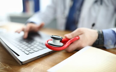 Therapist enters consultation data into laptop. Remote provision medical advice. Consult via video...