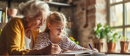 grandmother teaching granddaughter and helping her with homework at home. Copy space image. Place for adding text or design