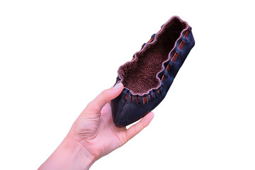 Woman holding a retro Shoe made of rough leather, isolated on a white background. The shoes are...