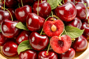 Close up shot Red Cherry on wooden background, Red Cherry fruit in wooden basket on wooden table.
