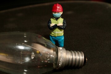 miniature figurine of an electrician with a light bulb